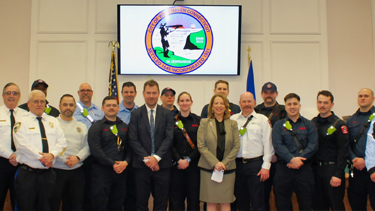 Jens Frederiksen and Dorinda Borer standing with first responders from West Haven.