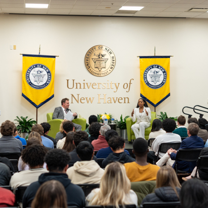 Controller Malia Cohen speaking with President Jens Frederiksen at the University of New Haven’s Frederiksen Forum: Trailblazing Women speaker series addressing a crowded room full of students